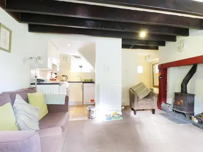 a living room with a couch and a fireplace at Nightingale Cottage in Threlkeld