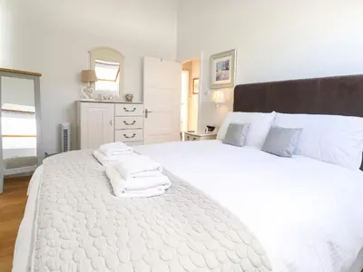 a bedroom with a large white bed with towels on it at Sky View in Keswick