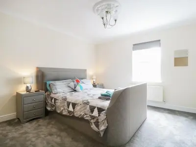 a bedroom with a bed with a night stand and a window at Fox's Den in Keswick