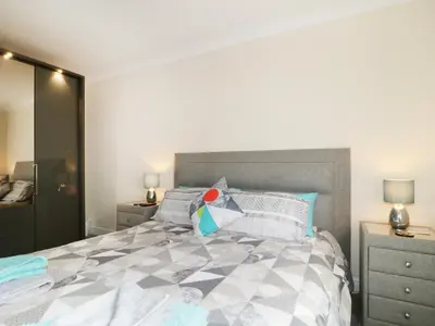 a bedroom with a large bed and two night stands at Fox's Den in Keswick