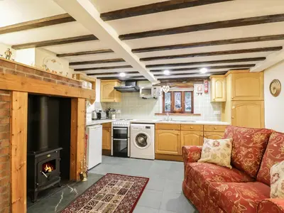 a living room with a red couch and a stove at The Old Barn in Nether Wasdale
