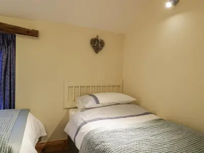 two twin beds in a room with a window at The Old Barn in Nether Wasdale