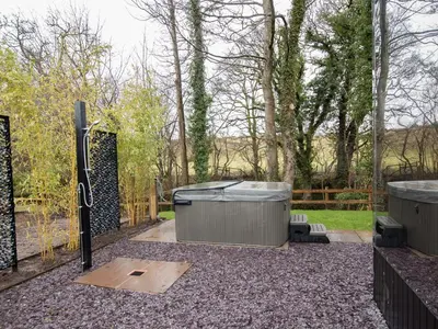 a backyard with two hot tubs and a fence at Reflection in Canonbie