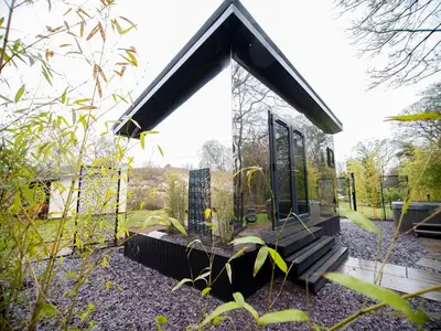a small house with a glass door on a yard at Reflection in Canonbie
