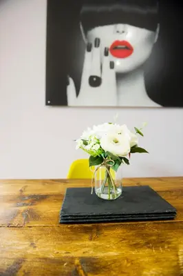 a glass vase with white roses on a table at The Old Wool House Apartments in Carlisle