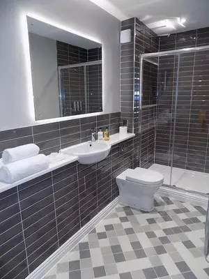 a bathroom with a toilet and a sink and a mirror at The Old Wool House Apartments in Carlisle
