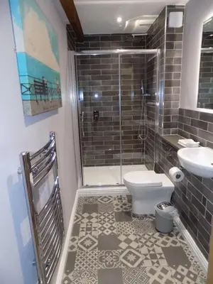 a bathroom with a shower and a toilet and a sink at The Old Wool House Apartments in Carlisle