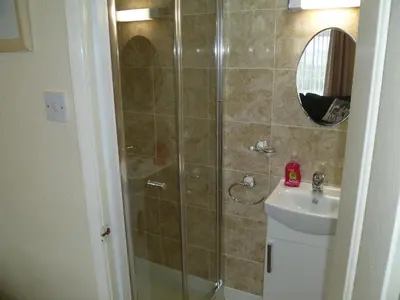 a bathroom with a shower and a toilet and a sink at Greenlaw Guest House in Gretna Green