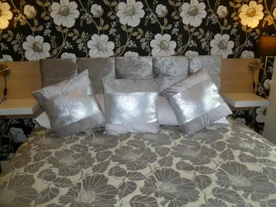 a bed with silver pillows in a bedroom at Greenlaw Guest House in Gretna Green