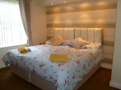 a bedroom with a bed with two yellow towels on it at Greenlaw Guest House in Gretna Green
