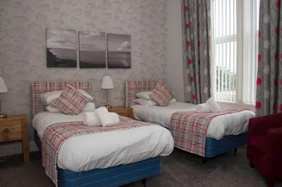 a hotel room with two beds and a window at Craignelder Hotel in Stranraer
