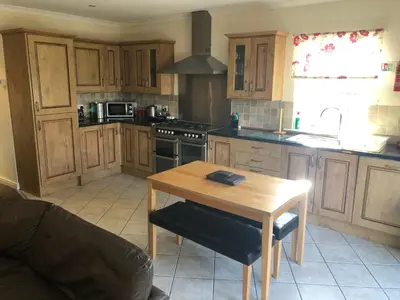 a kitchen with wooden cabinets and a wooden table with a wooden table sidx sidx sidx at Irton Hall in Eskdale