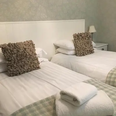 a hotel room with two beds with towels on them at Littletown Farm Guest House in Keswick