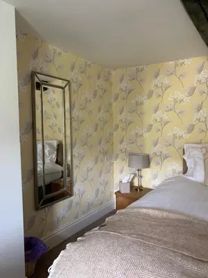 a bedroom with a bed and a mirror at Littletown Farm Guest House in Keswick