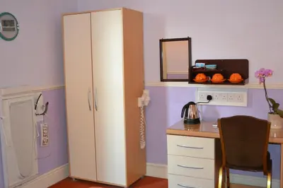 a room with a desk and a large white cabinet at Adelphi Guest House in Douglas