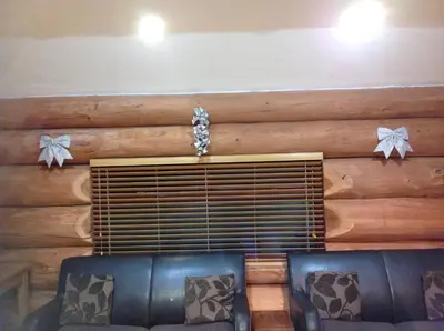 a living room with a log wall and two chairs at lyne view, log cabin in Carlisle