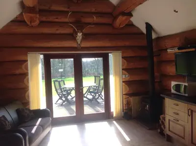 a living room with a sliding glass door to a patio at lyne view, log cabin in Carlisle