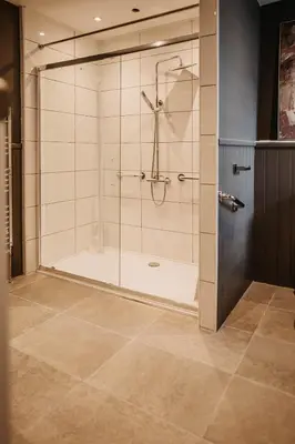 a bathroom with a shower with a glass door at The Murray Arms Hotel in Gatehouse of Fleet