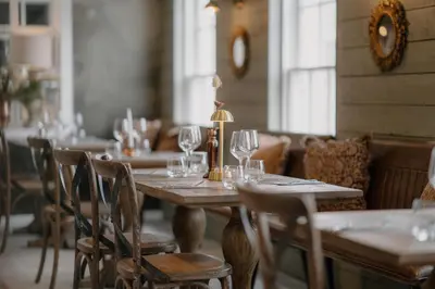 a dining room with tables and chairs with wine glasses at The Murray Arms Hotel in Gatehouse of Fleet