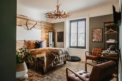 a bedroom with a bed and a desk and a chair at The Murray Arms Hotel in Gatehouse of Fleet