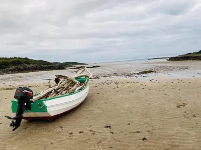 a small boat sitting on a sandy beach at Jack's Hideaway in Gatehouse of Fleet