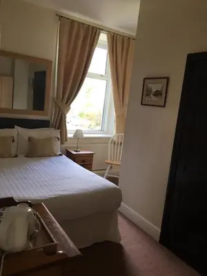 a bedroom with a large bed and a window at Lincoln Guest House in Keswick