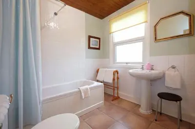 a bathroom with a tub and a sink and a bath tub at Lincoln Guest House in Keswick