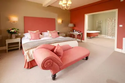 a bedroom with a large bed and a bench in it at Eltermere Inn in Elterwater