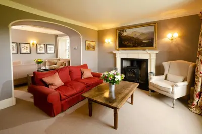 a living room with a red couch and a fireplace at Eltermere Inn in Elterwater
