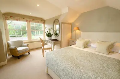 a bedroom with a bed and a desk and a chair at Eltermere Inn in Elterwater