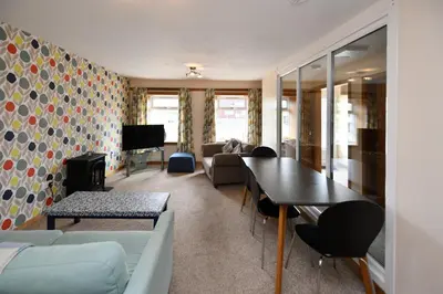 a living room with a couch and a table at Pottery Cottage, Lochans Lodge in Stranraer