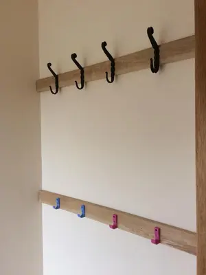 a row of wooden hooks on a wall at Pottery Cottage, Lochans Lodge in Stranraer