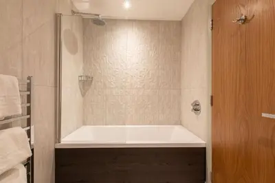 a bath tub in a bathroom with a shower at Royal Hotel in Cumnock