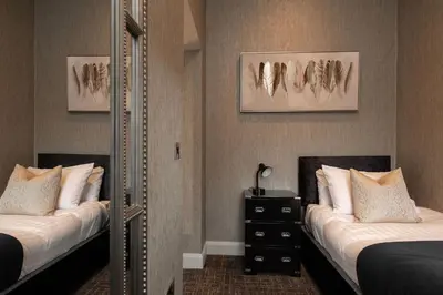 a bedroom with two beds and a mirror at Royal Hotel in Cumnock