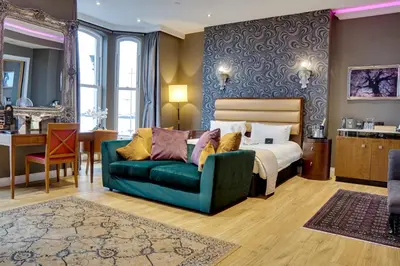 a bedroom with a bed and a green couch at Halvard Hotel in Douglas
