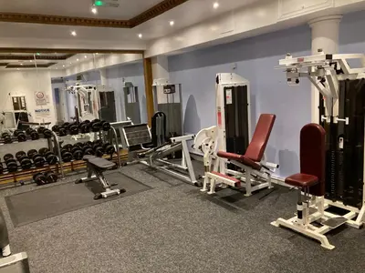a gym with several treadms and machines in a room at Washington Central Hotel and Sleepwell Inn in Workington