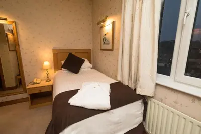 a hotel room with two beds and a window at Washington Central Hotel and Sleepwell Inn in Workington