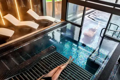 a person sitting on a bench next to a swimming pool at Langdale Hotel & Spa in Ambleside