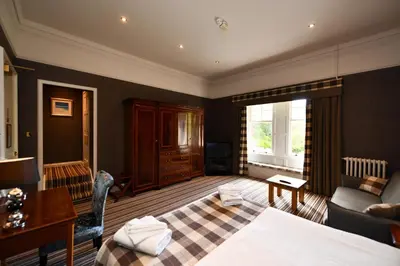 a living room with a bed and a couch at Savoy Park Hotel in Ayr