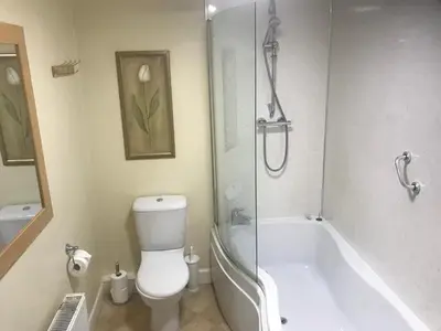 a bathroom with a tub and a toilet and a shower at Creebridge House Hotel in Newton Stewart