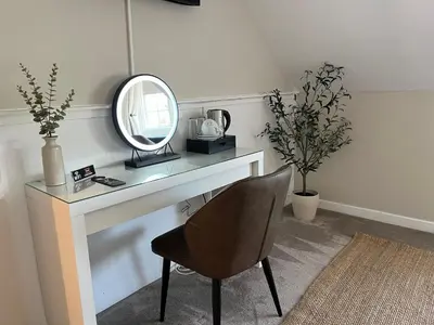 a dressing table with a mirror and a chair at Harbourside Hotel in Irvine