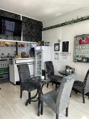 a restaurant with two tables and chairs and a kitchen at Edelweiss Guest House in Douglas