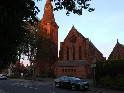 a black car parked in front of a church at Lindean Guest House in Dumfries