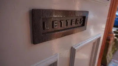 a sign on a door with the word letters on it at Lindean Guest House in Dumfries