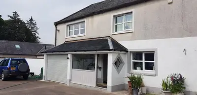 a large white house with a garage at Newby Cross in Carlisle