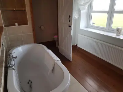 a white bath tub in a bathroom with a window at Newby Cross in Carlisle