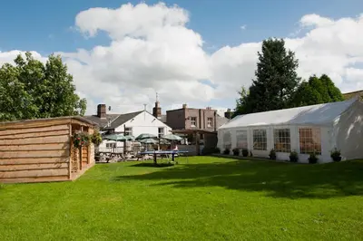 a yard with a white tent and a building at Boot & Shoe Inn in Greystoke