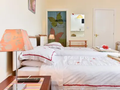 a bedroom with two beds and a table with a lamp at The Warren Guest House in Carlisle