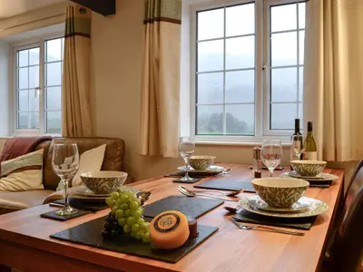 a dining room table with wine glasses and grapes on it at Castle Howe in Rosthwaite