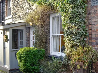 an ivy covered house with a white window at Jasmine Cottage in Keswick